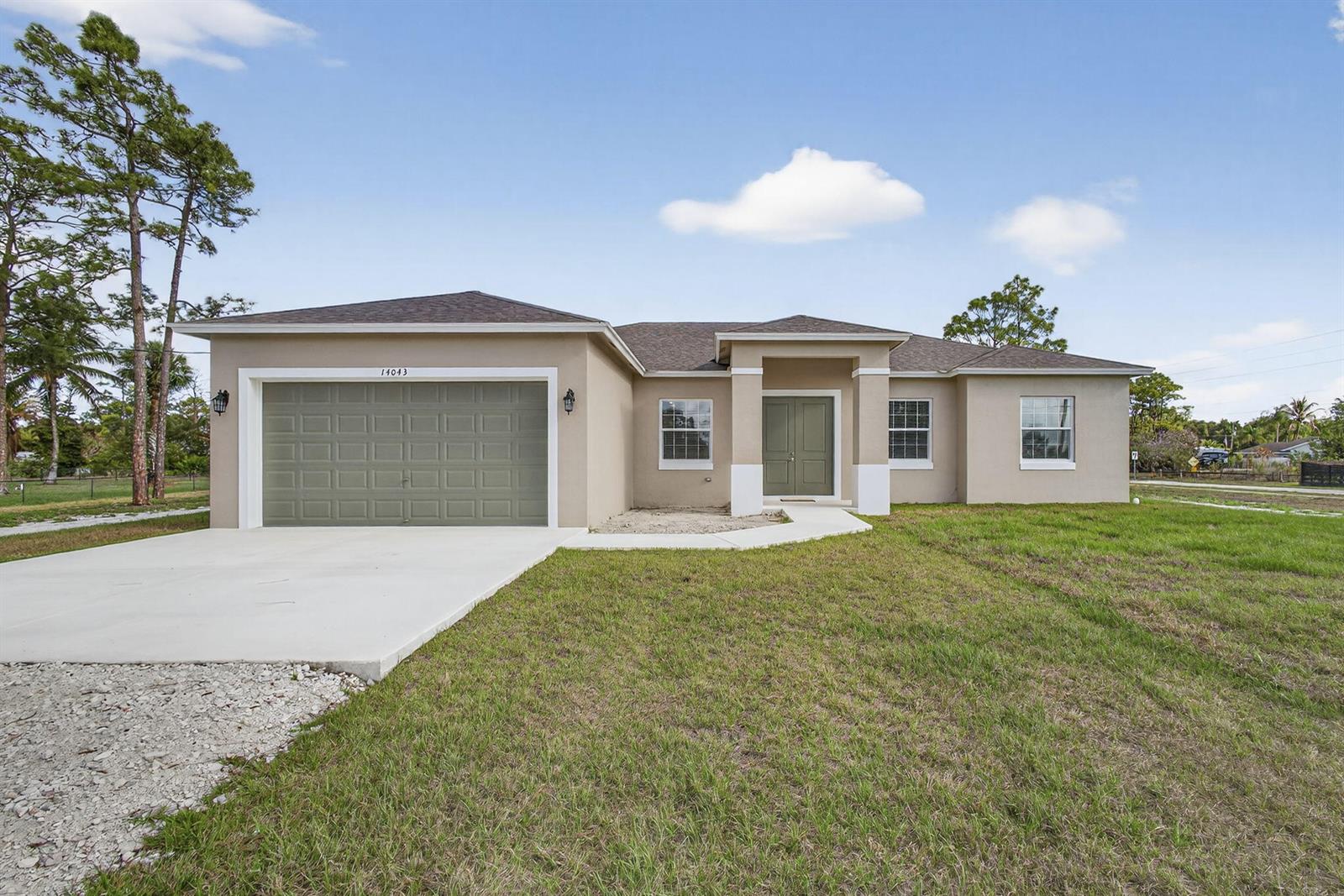 A single-story house with a beige stucco exterior, a green garage door, and a front porch — 14043 87th Street N, Loxahatchee FL 33470, LOXAHATCHEE, FL