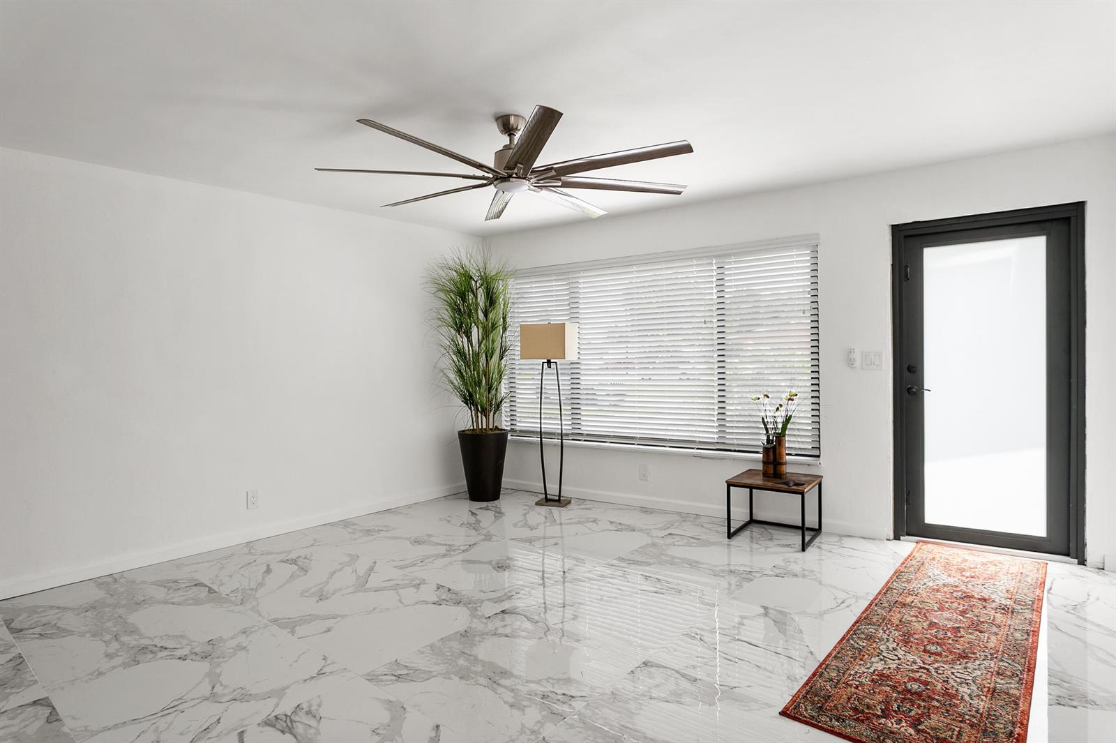 A modern kitchen features white upper cabinets, dark wood lower cabinets, and grey stone walls — 3141 NE 14th Avenue, Pompano Beach FL 33064, POMPANO BEACH, FL