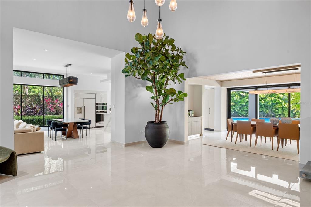 A spacious, open-concept living area features polished tile floors, a large potted plant, and chandeliers — 366 DORADO BEACH EAST, DORADO, PR