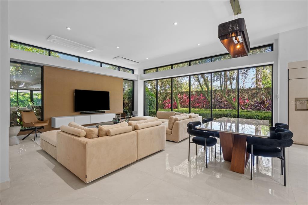 A modern open-concept living and dining room with floor-to-ceiling windows and light tile flooring — 366 DORADO BEACH EAST, DORADO, PR