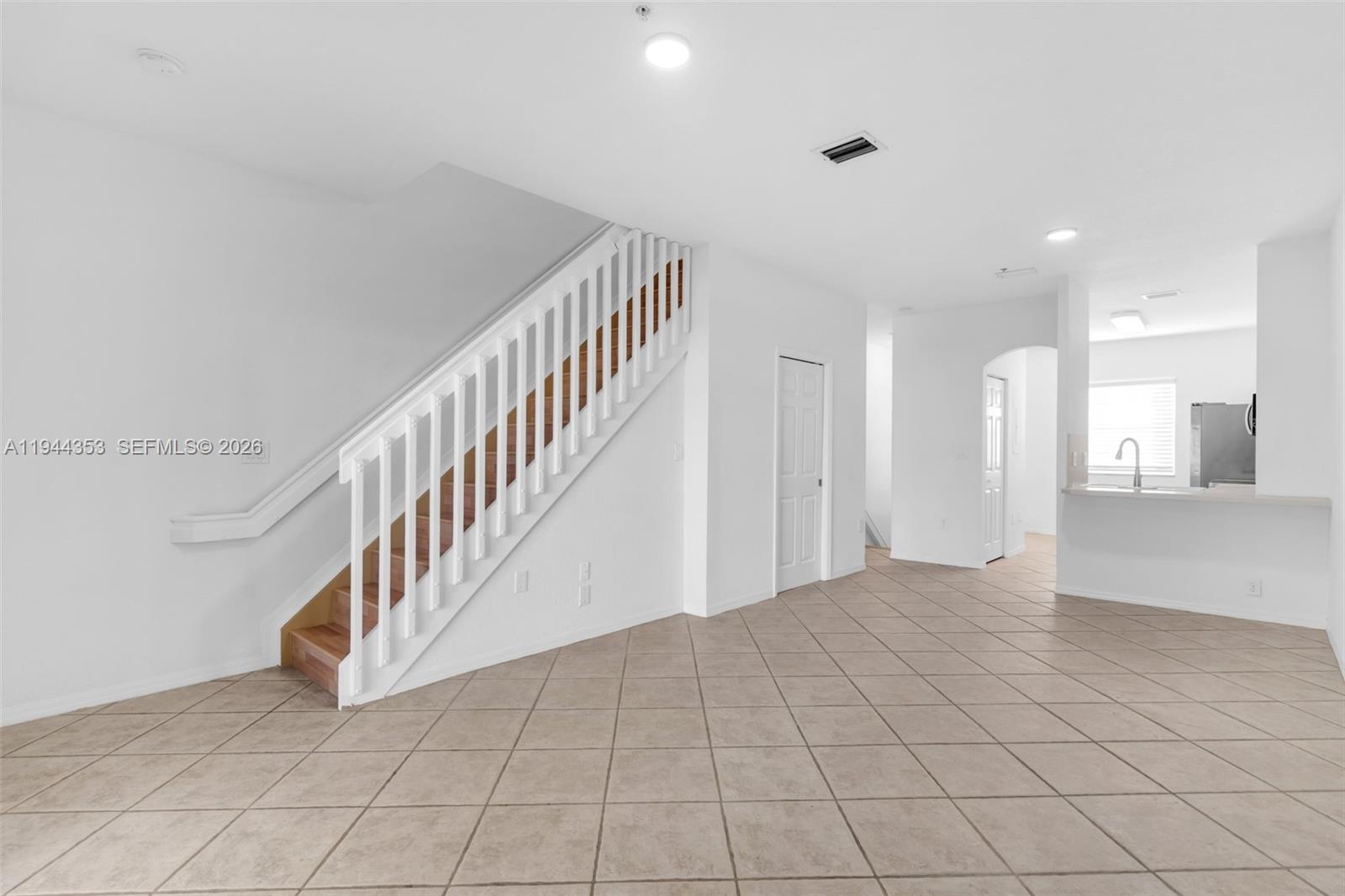 An interior view shows a tiled living area with a staircase and an adjacent kitchen — 5670 NW 116th Ave # 219, Doral FL 33178, DORAL, FL