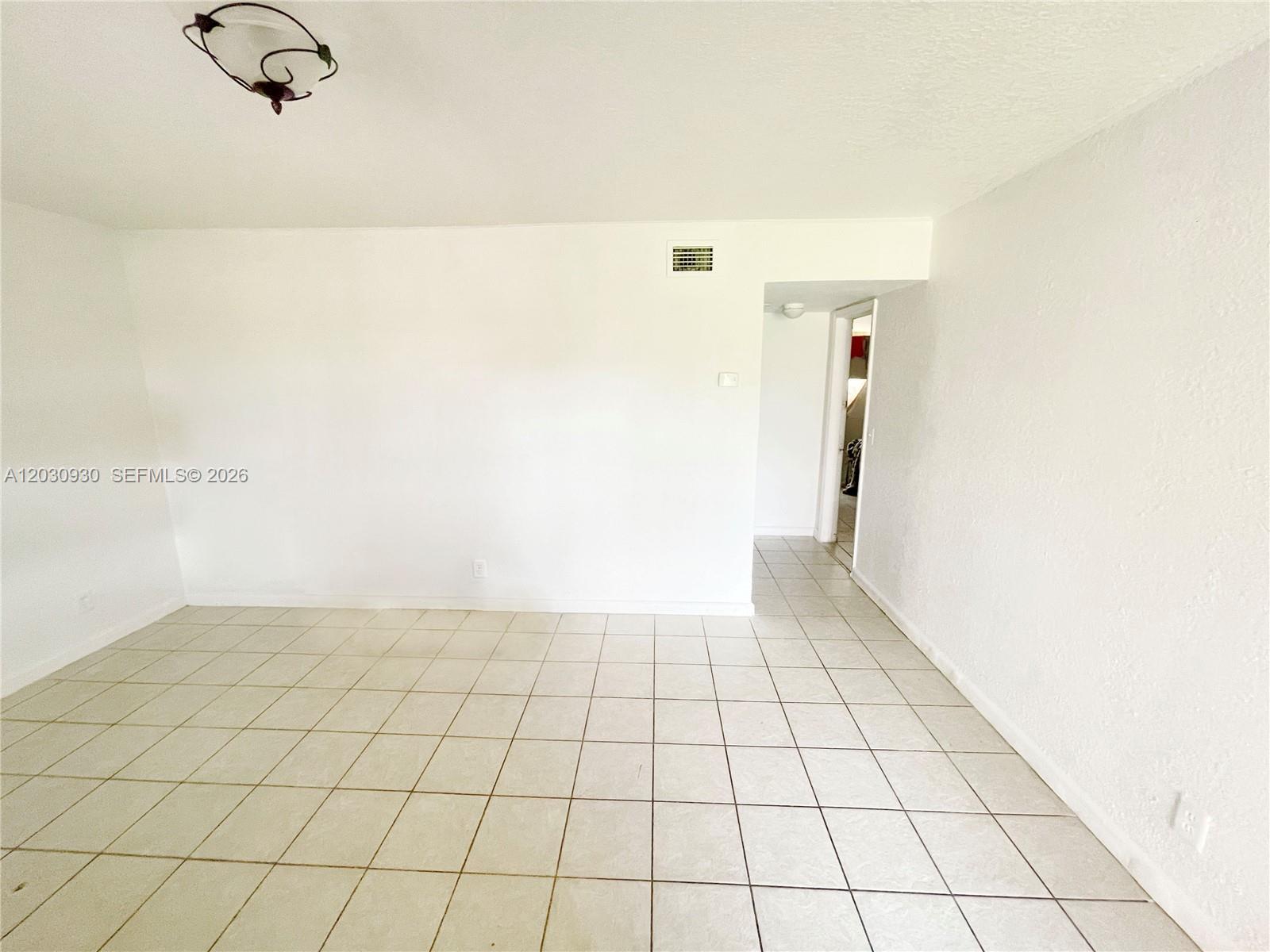 An empty room features white walls, a tiled floor, and a doorway leading elsewhere — 1829 N A St # 51, Lake Worth FL 33460, LAKE WORTH, FL