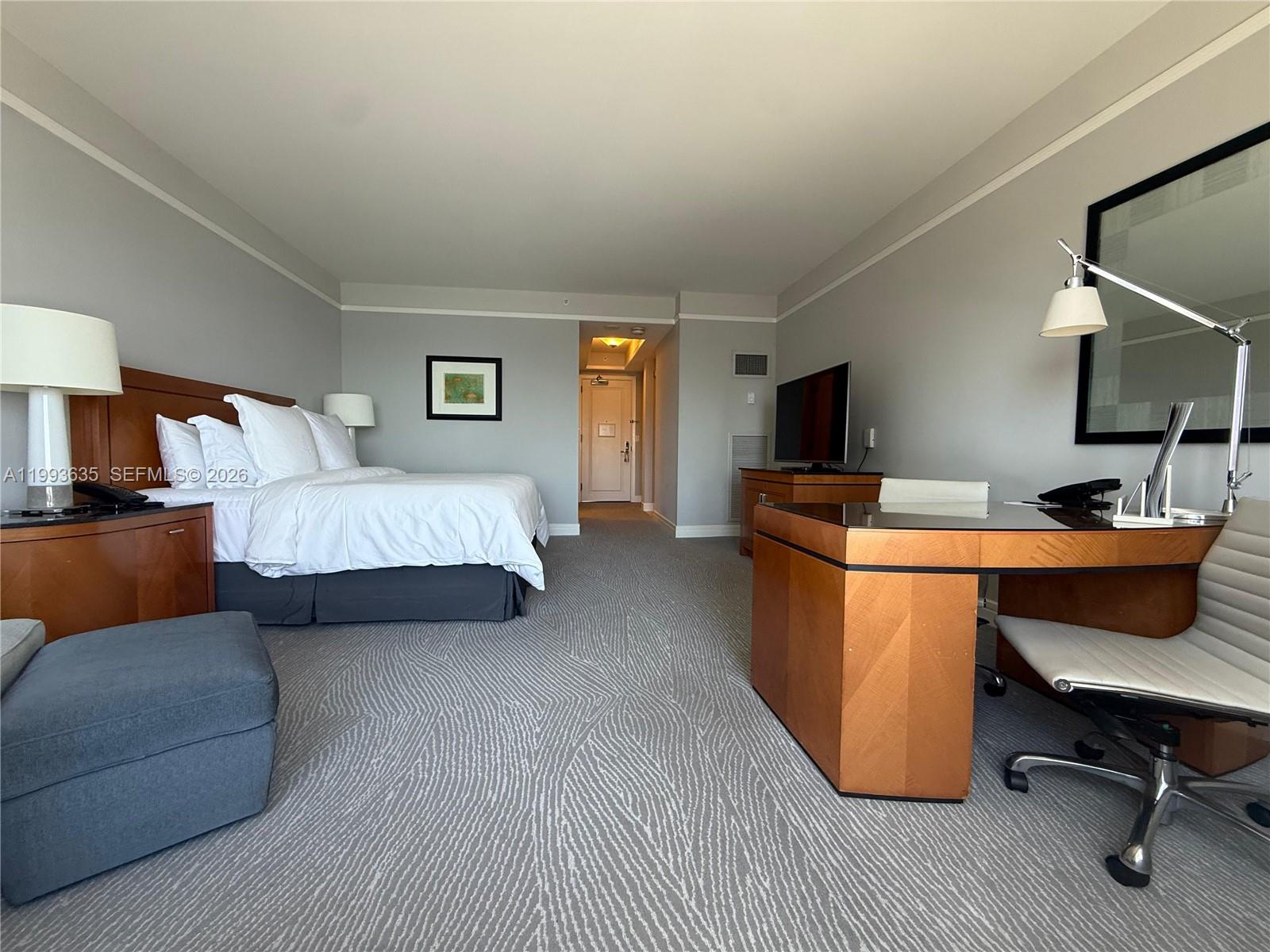 A hotel room features a bed, a desk with a chair, and gray carpeting — 1435 Brickell Ave # 3305, Miami FL 33131, MIAMI, FL