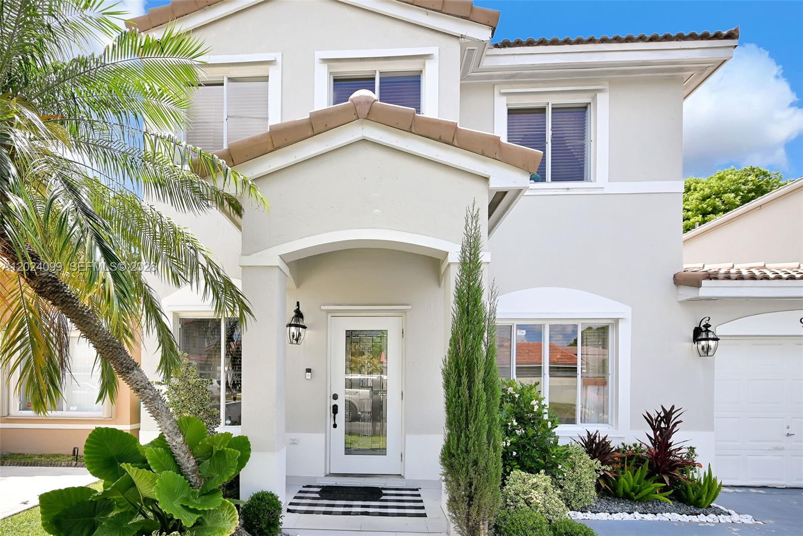 A two-story house with a beige stucco exterior, a tiled roof, and a front entryway — 9732 SW 166th Ct, Miami FL 33196, MIAMI, FL