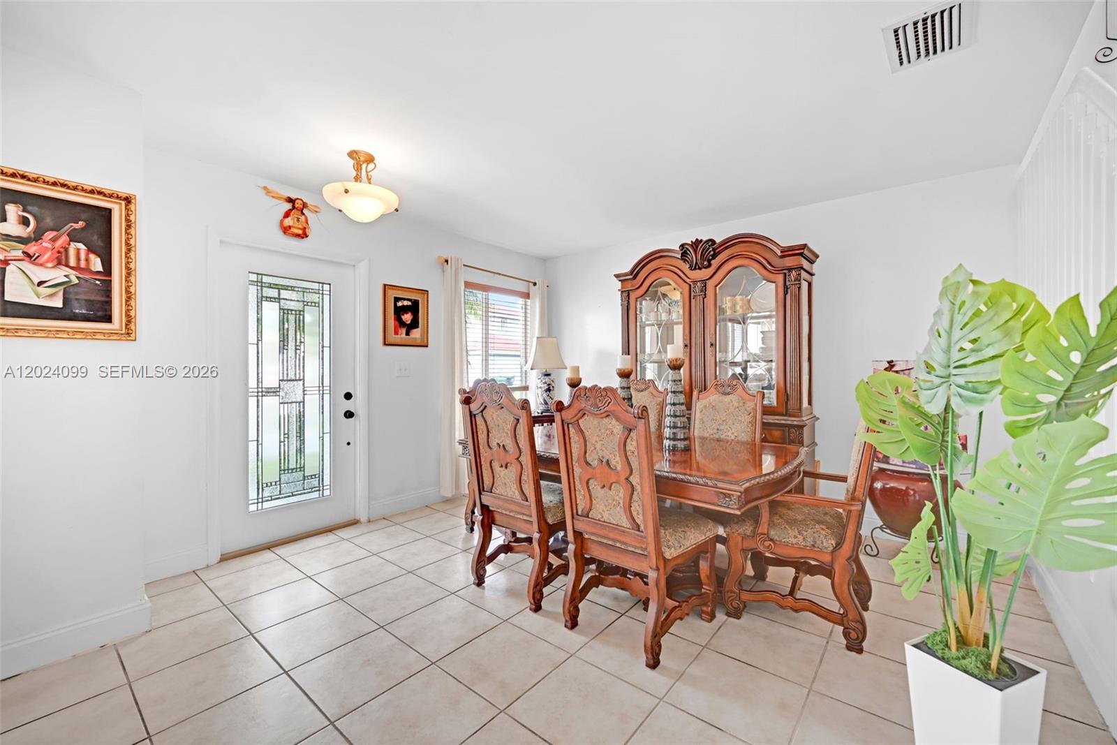 A dining room features a wooden table set, a china cabinet, and tile flooring — 9732 SW 166th Ct, Miami FL 33196, MIAMI, FL