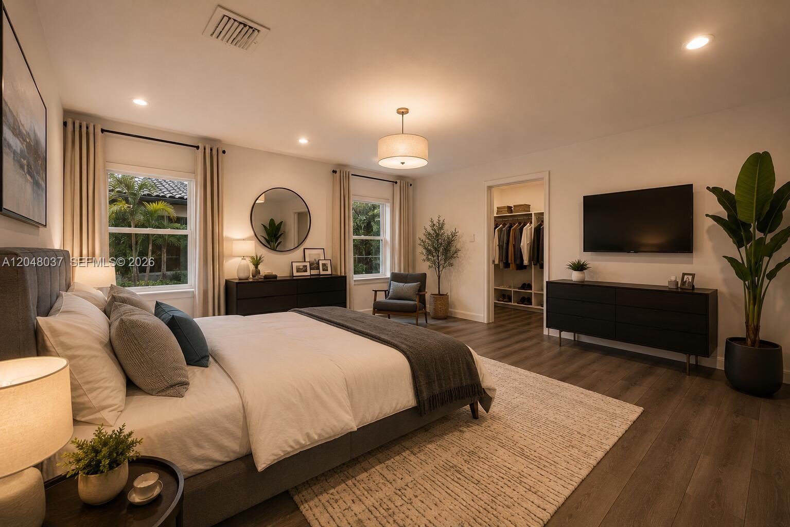 A bedroom features a king bed, dark wood flooring, a walk-in closet, and a television — 4740 N 31st Ct, Hollywood FL 33021, HOLLYWOOD, FL