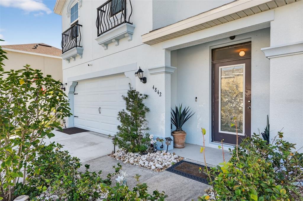 A two-story house exterior features a white stucco facade, a garage, and a front entrance — 4842 SAN PALERMO DRIVE, BRADENTON, FL