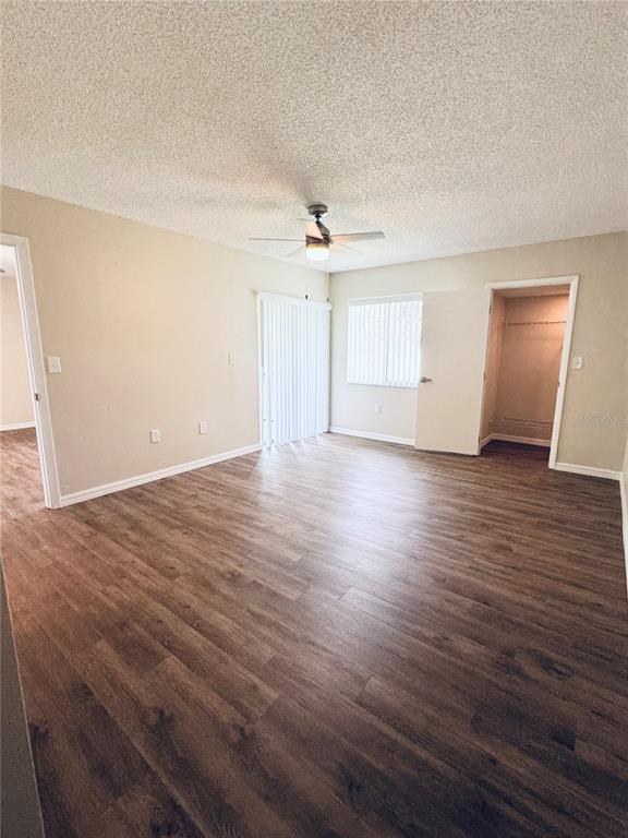A bedroom with wood-look flooring, a ceiling fan, a sliding glass door, and a closet — 134 CYPRESS COURT, OLDSMAR, FL