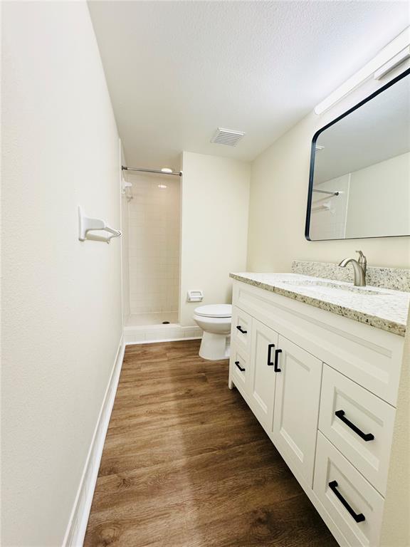 A bathroom features a white vanity with a granite countertop, a toilet, and a shower — 134 CYPRESS COURT, OLDSMAR, FL