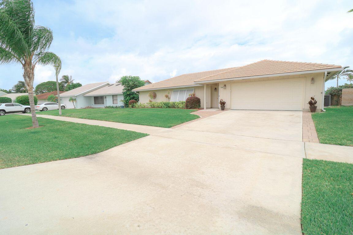 A single-story house with a beige exterior, tiled roof, and a concrete driveway — 73 Pine Hill Trail W, Jupiter FL 33469, JUPITER, FL