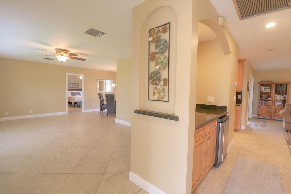 An open-concept living area features tile flooring, a decorative wall niche, and light-colored walls — 73 Pine Hill Trail W, Jupiter FL 33469, JUPITER, FL