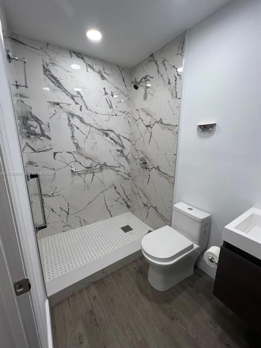 A bathroom features a walk-in shower with marble-patterned tile, a toilet, and a vanity — 6492 SW 25th St, Miramar FL 33023, MIRAMAR, FL