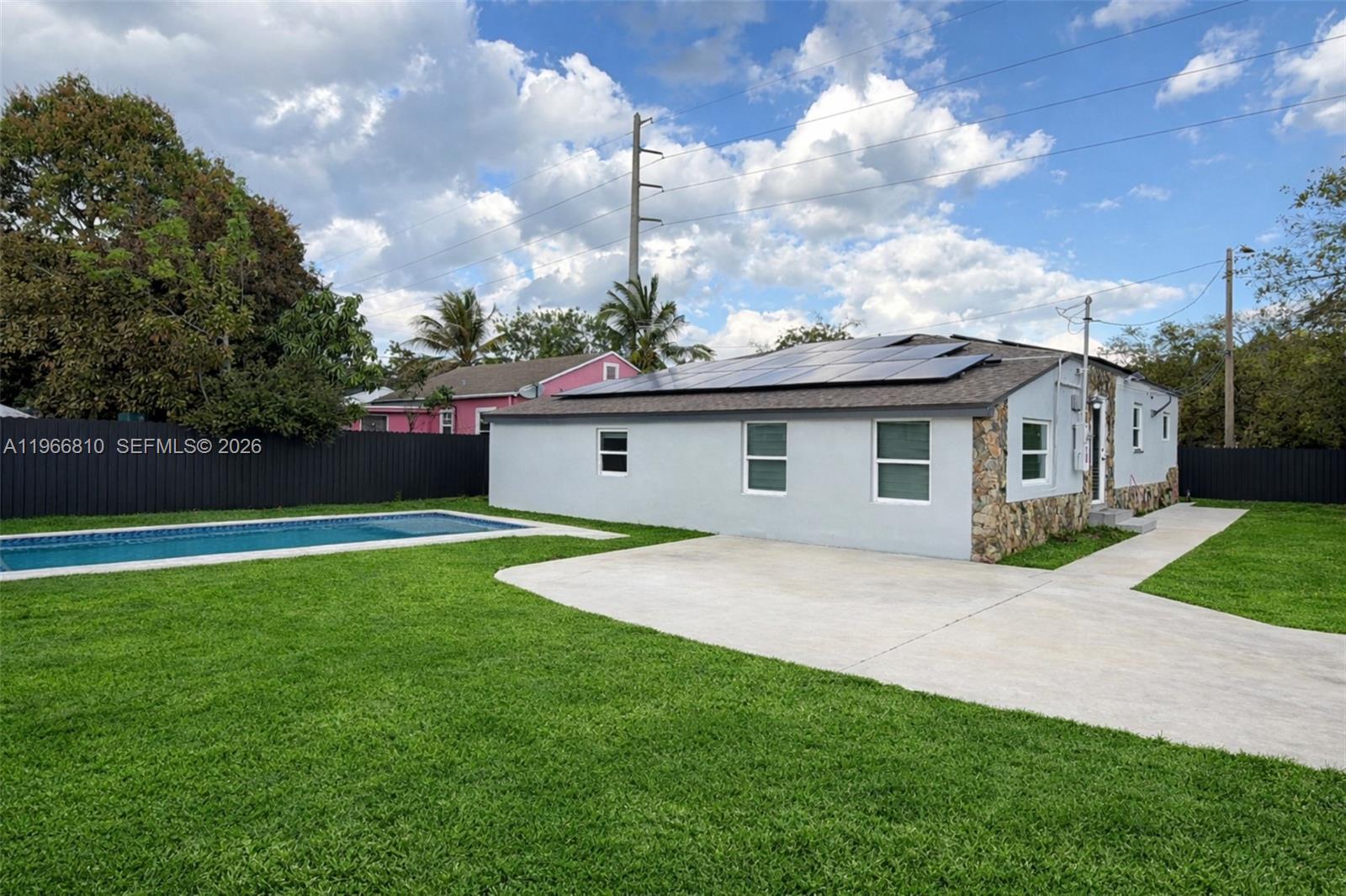 A single-story house with solar panels, a stone facade, and a swimming pool in the yard — 4500 NW 3rd Ave, Miami FL 33127, MIAMI, FL