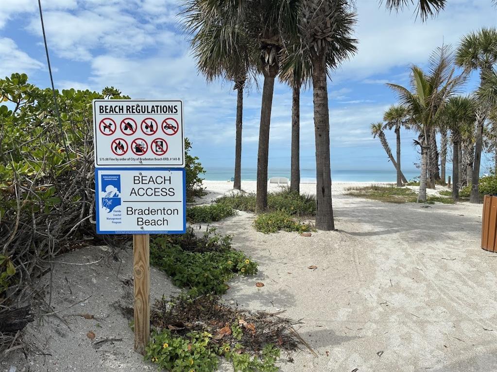 A sign detailing beach regulations stands at the entrance to a sandy beach path — 104 1ST STREET N, BRADENTON BEACH, FL