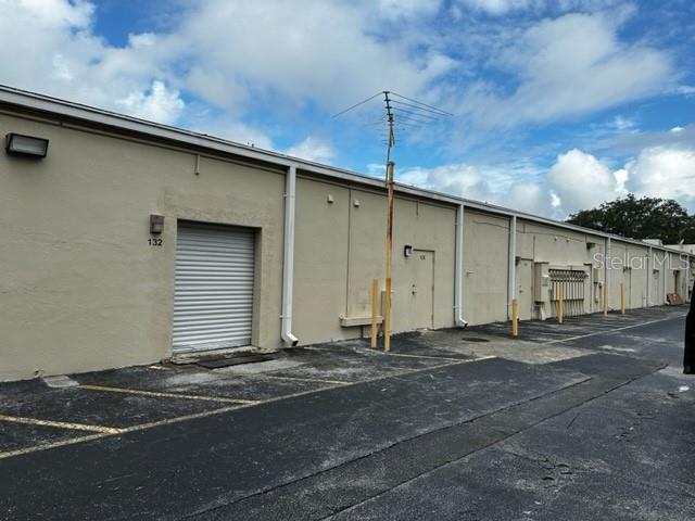 The exterior of a beige commercial building features a roll-up door and a metal antenna — 1740 STATE ROAD 436, WINTER PARK, FL