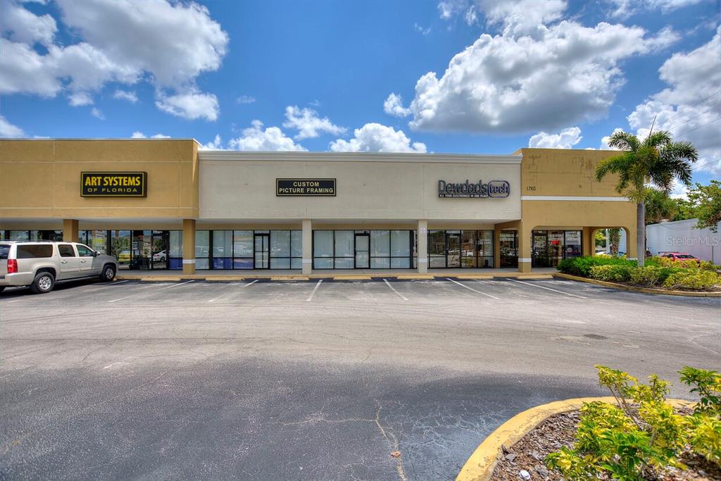 A commercial strip mall building with three storefronts under a cloudy blue sky — 1740 STATE ROAD 436, WINTER PARK, FL