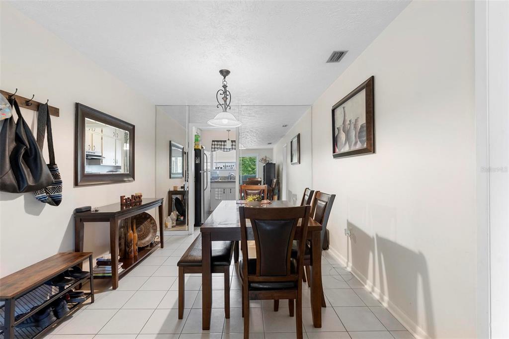 A dining room with a wooden table, chairs, a console table, and a mirrored wall — 4376 LAKE UNDERHILL ROAD UNIT C, ORLANDO, FL