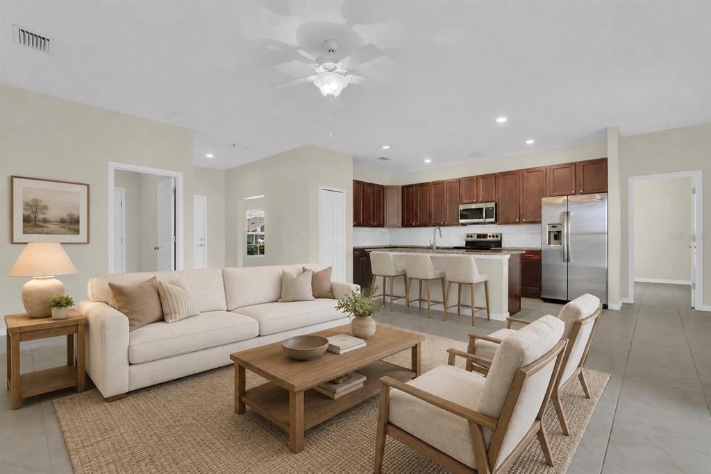 An open-concept living room and kitchen featuring a beige sofa, wooden coffee table, and island — 25599 DEEP CREEK BOULEVARD, PUNTA GORDA, FL