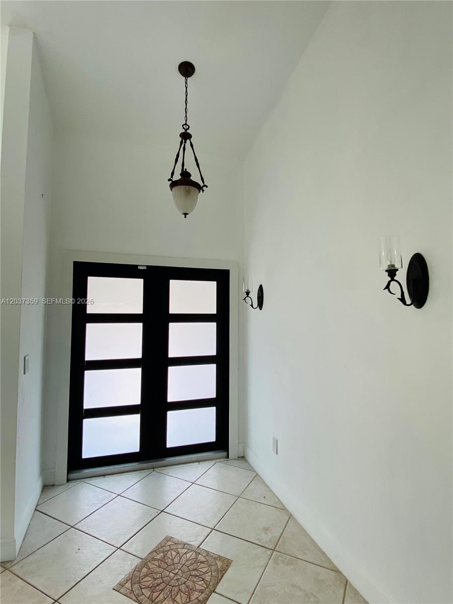 An entryway features a double door with frosted glass panels, tile flooring, and wall sconces — 8701 SW 191st St, Cutler Bay FL 33157, CUTLER BAY, FL