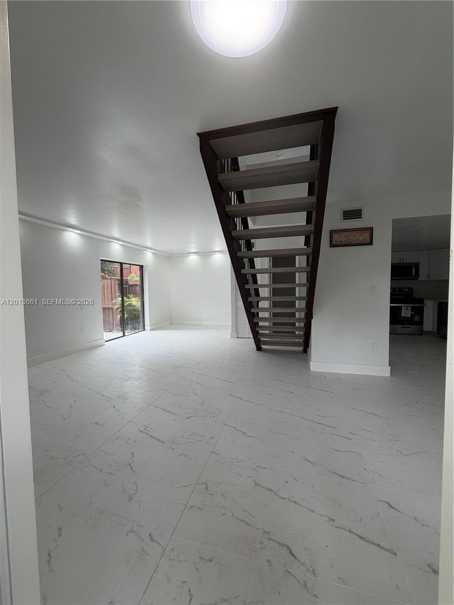 A living room features white marble-look tile flooring, recessed lighting, and an open staircase — 7024 SW 114th Pl # 52, Miami FL 33173, MIAMI, FL