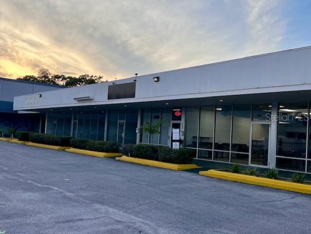 A single-story commercial building with a long glass storefront and a paved parking lot — 600 S PARK AVENUE, TITUSVILLE, FL