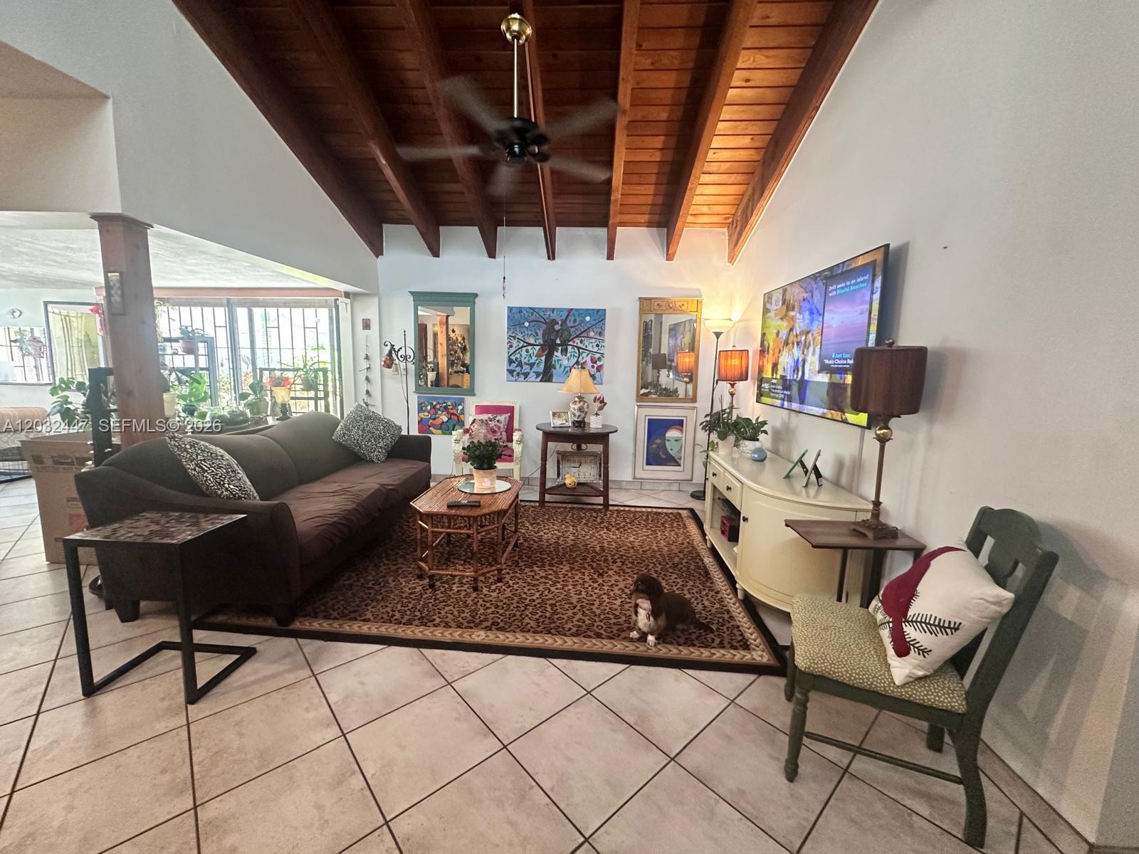 A living room features a vaulted wood-paneled ceiling, tile flooring, and a large leopard-print rug — 9119 SW 129th Ln # 0, Miami FL 33176, MIAMI, FL
