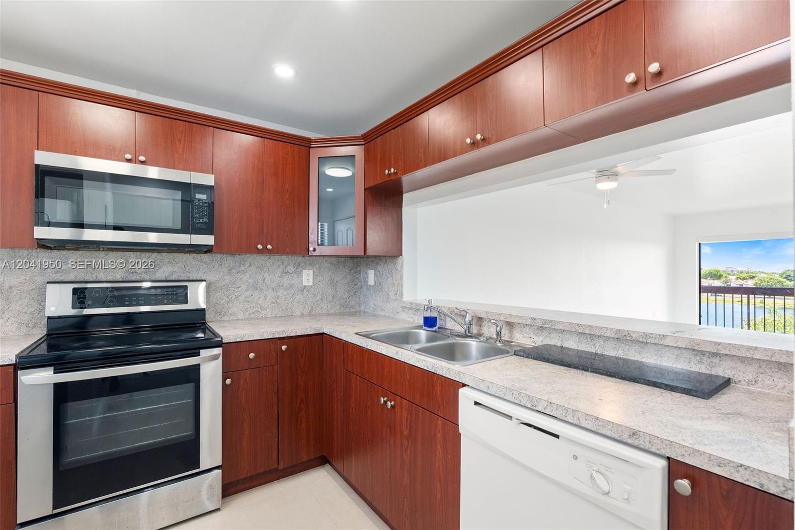 A kitchen features cherry wood cabinets, stainless steel appliances, and a view of the water — 10288 NW 9th St Cir # 501, Miami FL 33172, MIAMI, FL