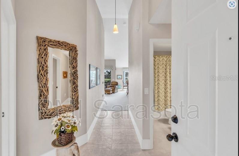 A hallway with tile flooring leads from an entryway toward a living area — 5320 HYLAND HILLS AVENUE UNIT 2225, SARASOTA, FL