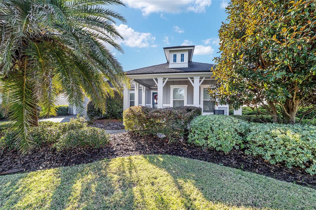 A single-story house with a covered front porch, a cupola, and lush landscaping — 11895 SW 33RD LANE, GAINESVILLE, FL