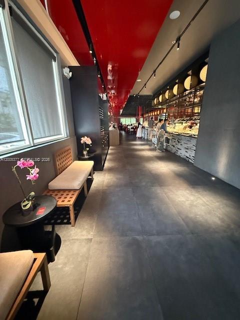 A modern restaurant interior features a long red ceiling, dark tile floors, and bench seating — University Dr, Coral Springs FL 33071, CORAL SPRINGS, FL