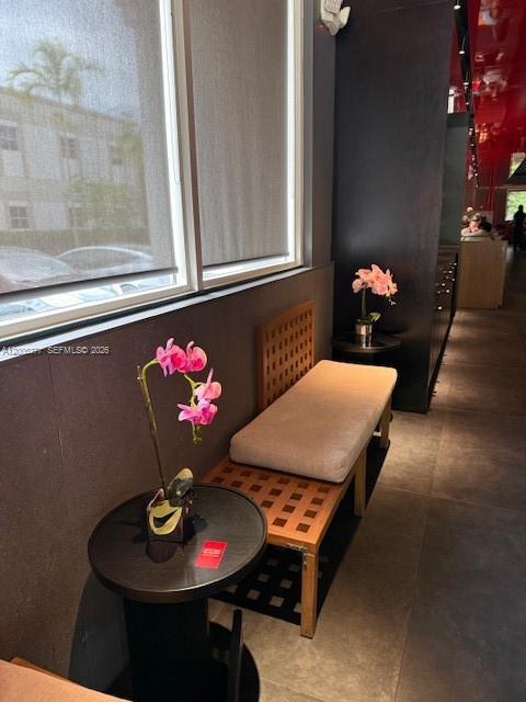 A wooden bench with a cushion sits next to a small table holding an orchid — University Dr, Coral Springs FL 33071, CORAL SPRINGS, FL