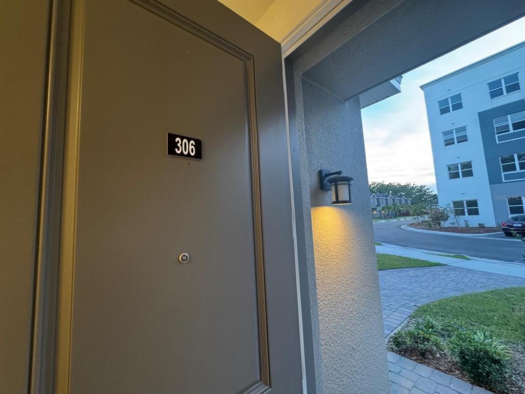 A view from an open doorway showing a unit number 306 and an exterior building — 1209 SOUTHSTATION PLACE UNIT 306, ORLANDO, FL