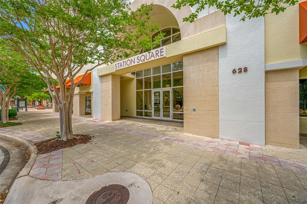 The exterior entrance of a building labeled Station Square features a glass door and windows — 628 CLEVELAND STREET UNIT 1313, CLEARWATER, FL