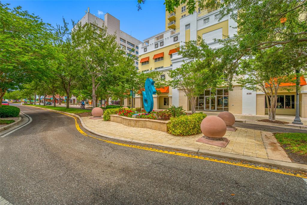 A blue seahorse sculpture stands in a landscaped island in front of a multi-story building — 628 CLEVELAND STREET UNIT 1313, CLEARWATER, FL