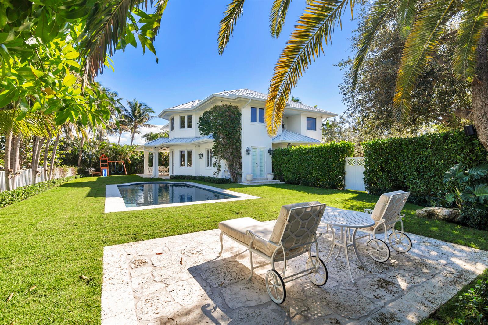 A white two-story house with a swimming pool and patio furniture in the backyard — 2614 Furman Lane, FL 33460, FL