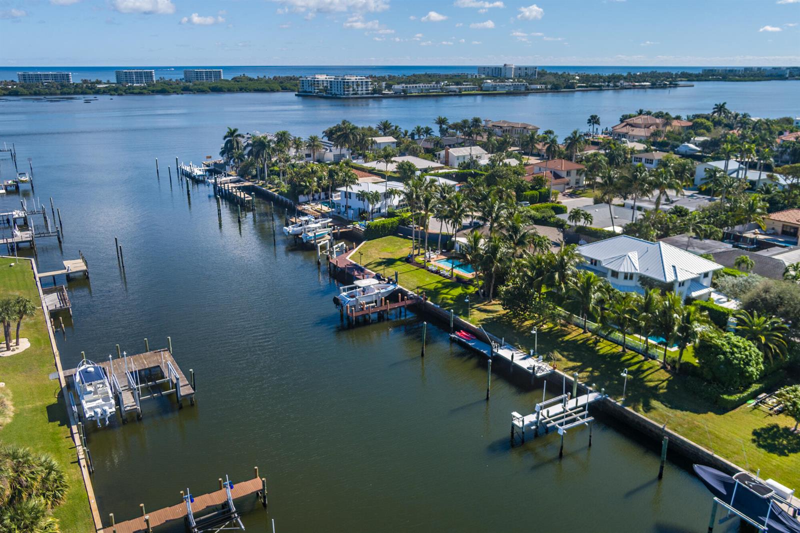 An aerial view shows waterfront homes with private docks and boats along a canal — 2614 Furman Lane, FL 33460, FL