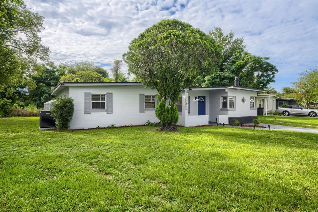 A single-story white house with a large tree in the front yard — 201 HAYS DRIVE, SANFORD, FL