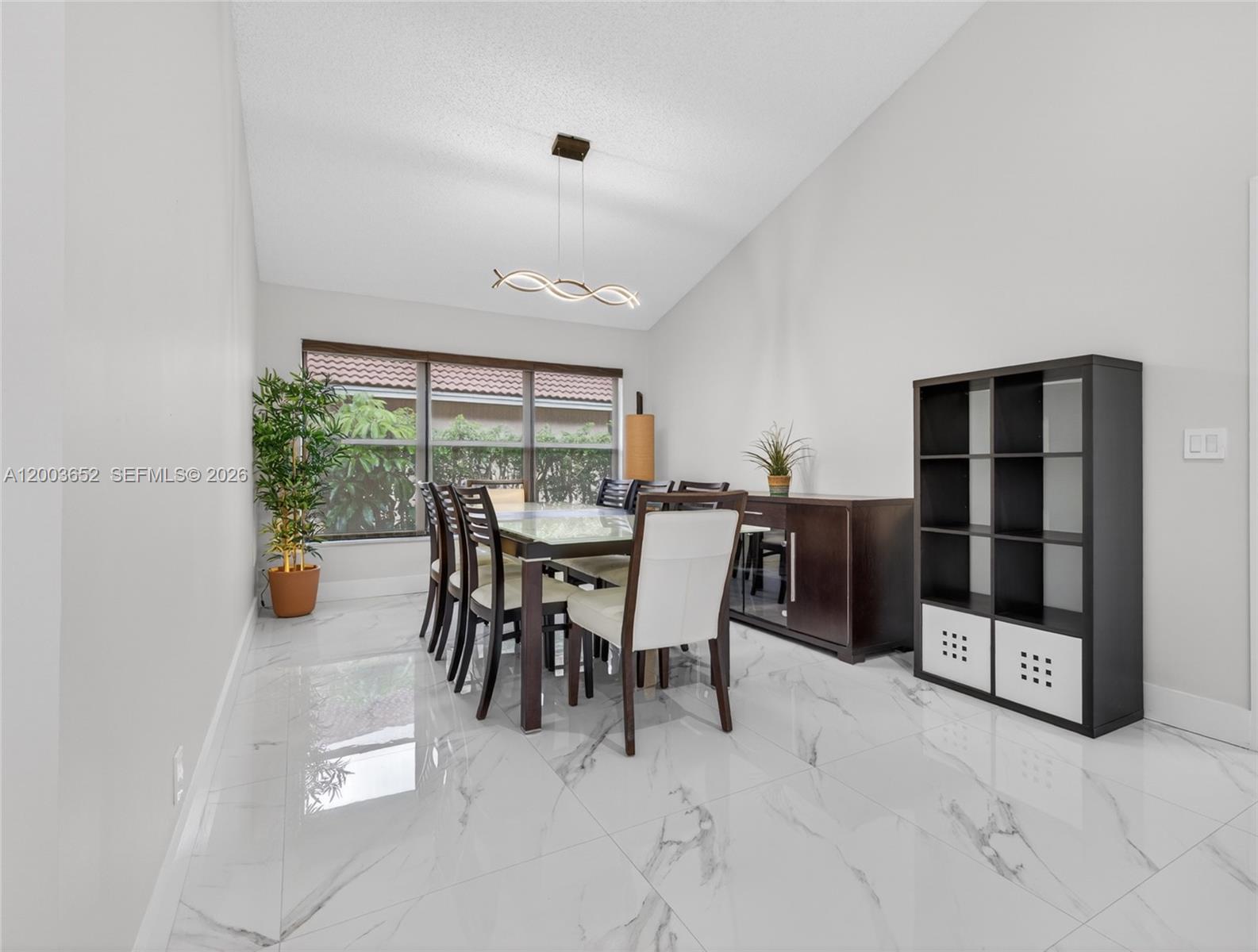 A dining room features a glass-top table, white chairs, and white marble-patterned tile flooring — 1025 Creekford Dr, Weston FL 33326, WESTON, FL
