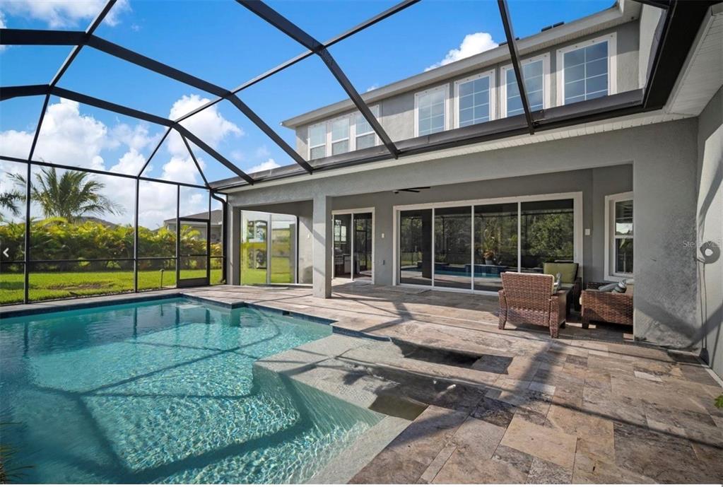 A screened-in patio features a swimming pool with steps and a paved deck area — 7004 MAINLAND AVENUE, APOLLO BEACH, FL