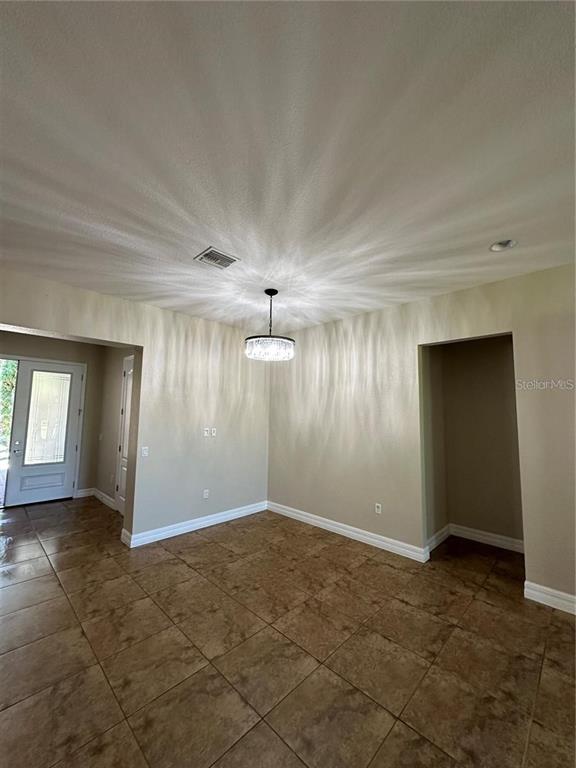 A dining area features tile flooring, a crystal chandelier, and an entryway with a door — 8244 PRESTBURY DRIVE, ORLANDO, FL