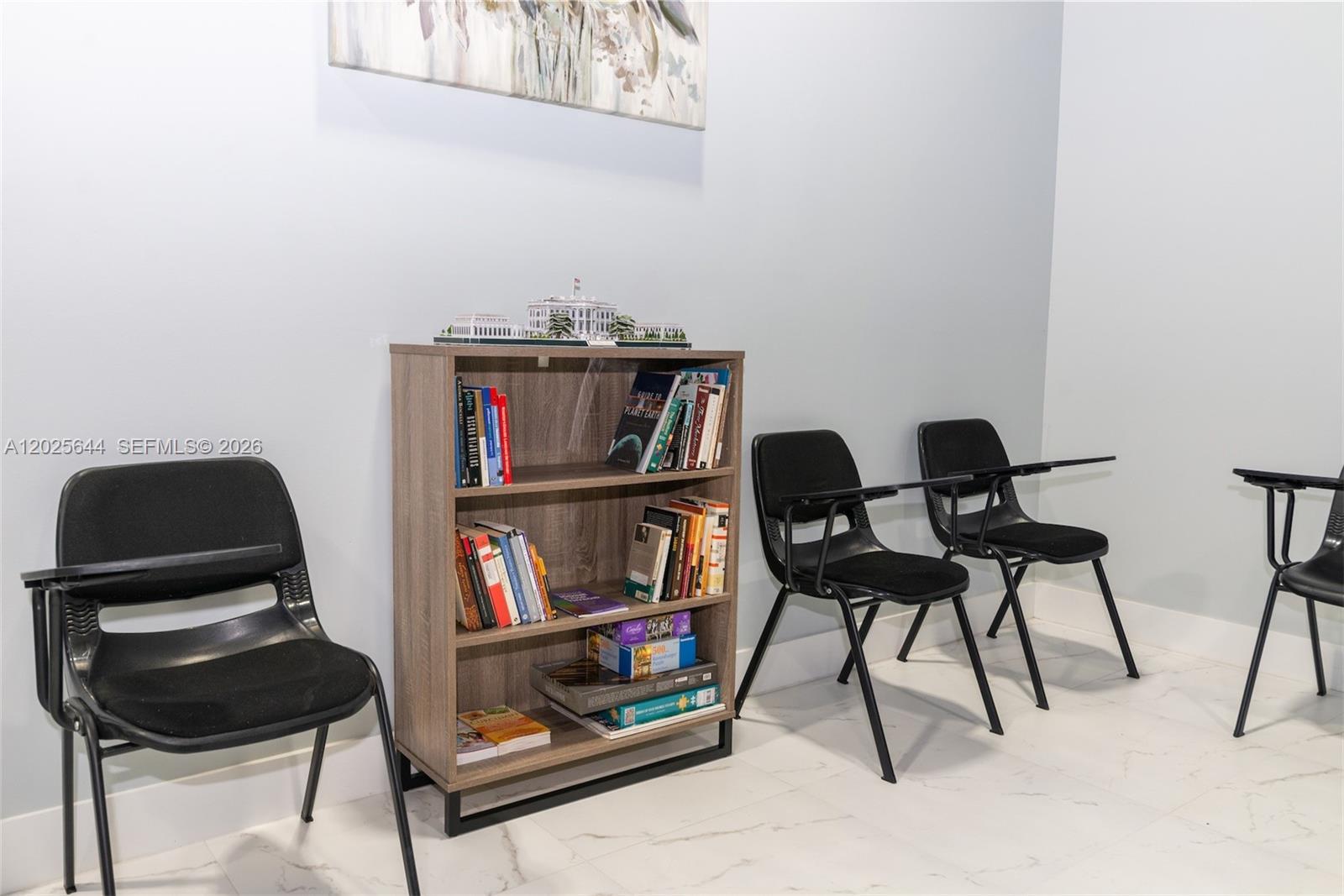 A large, open-concept community room features dining tables, rows of recliners, and exposed industrial ceilings — MIRAMAR, FL