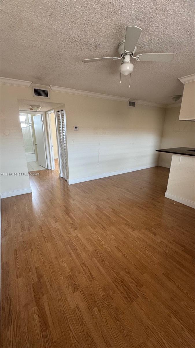 An interior view shows a living area with wood-look flooring and a ceiling fan — 2441 SW 31st Ave # 303, Miami FL 33145, MIAMI, FL