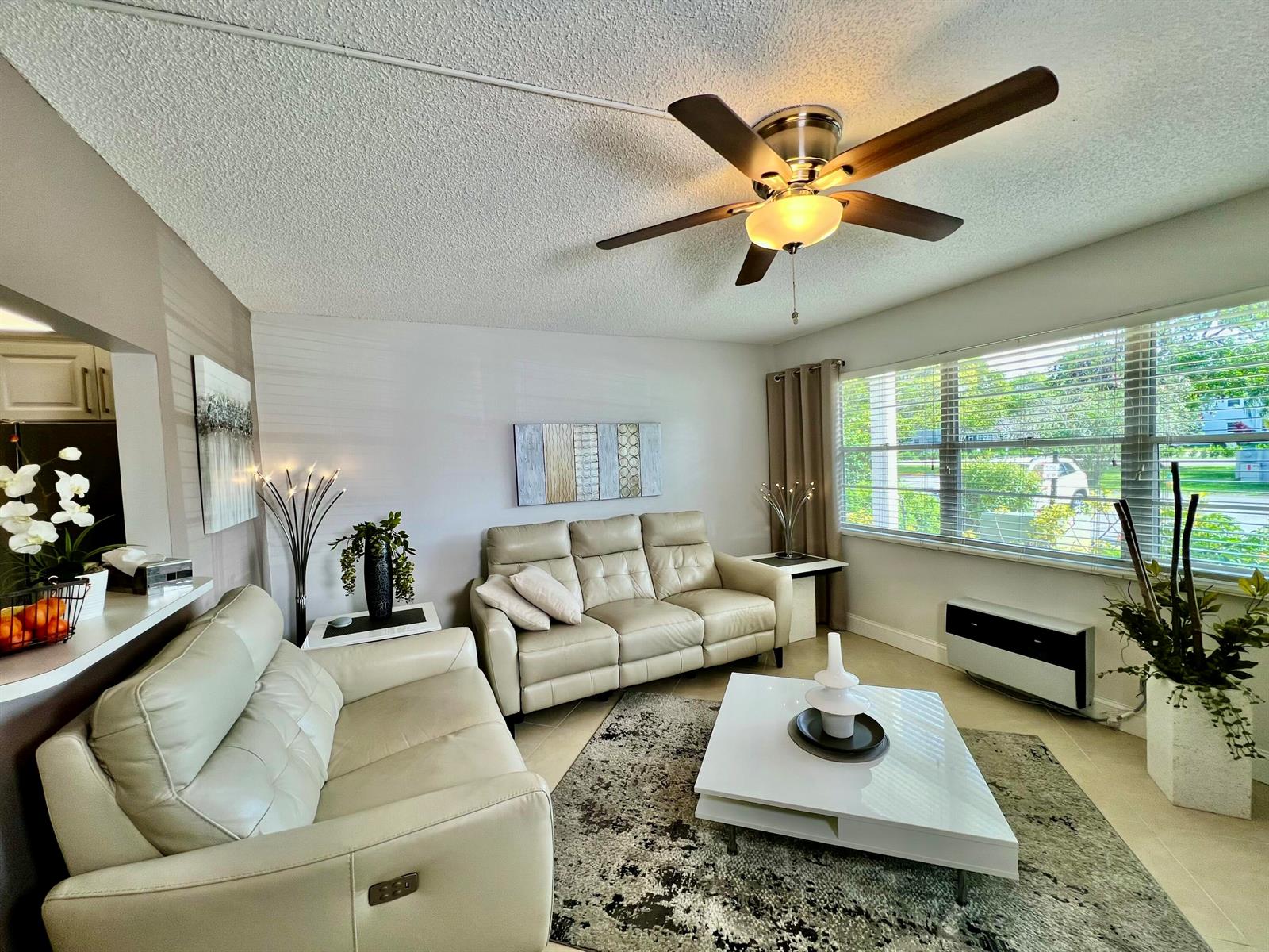 A living room features two beige leather sofas, a white coffee table, and a ceiling fan — 172 Tilford I, Deerfield Beach FL 33442, DEERFIELD BEACH, FL