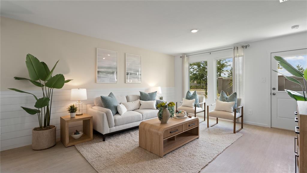 A living room features a light-colored sofa, two armchairs, a coffee table, and shiplap walls — 286 CERAMIC COURT, GROVELAND, FL
