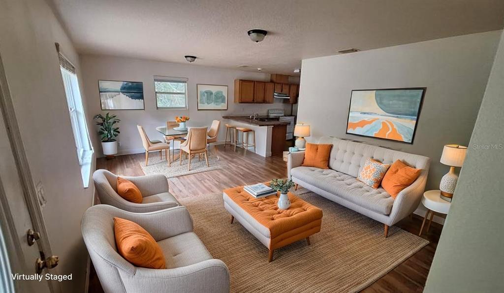 A living room with a sectional sofa, wooden coffee table, and open kitchen with bar seating — 788 N CHARLES AVENUE, INVERNESS, FL