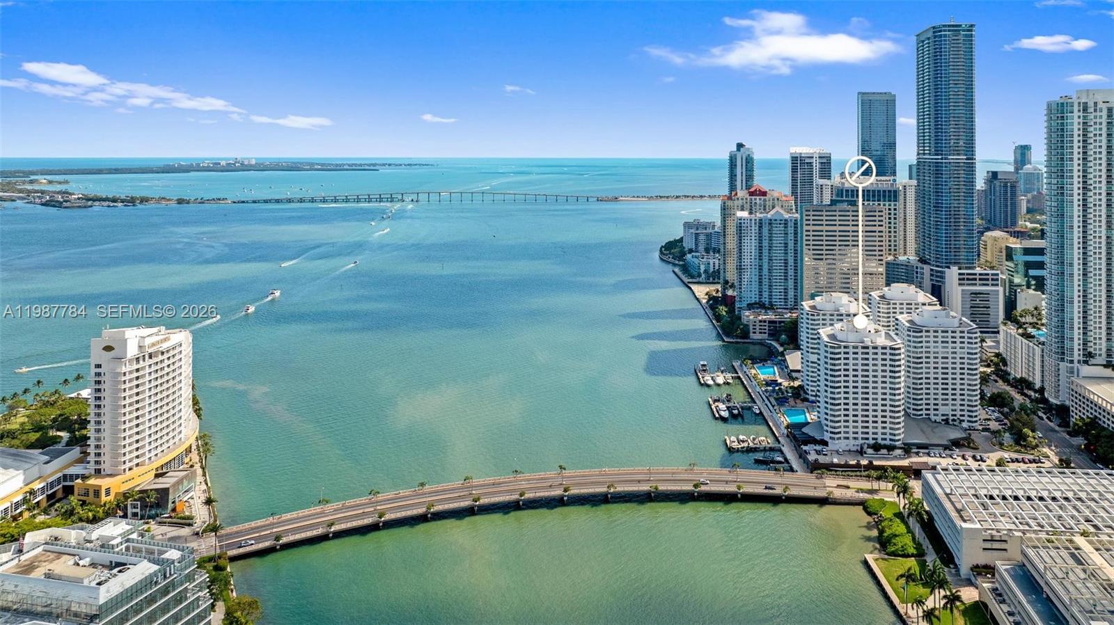 An aerial view shows a coastal city skyline with high-rise buildings, a bridge, and water — 801 Brickell Bay Dr # 361, Miami FL 33131, MIAMI, FL
