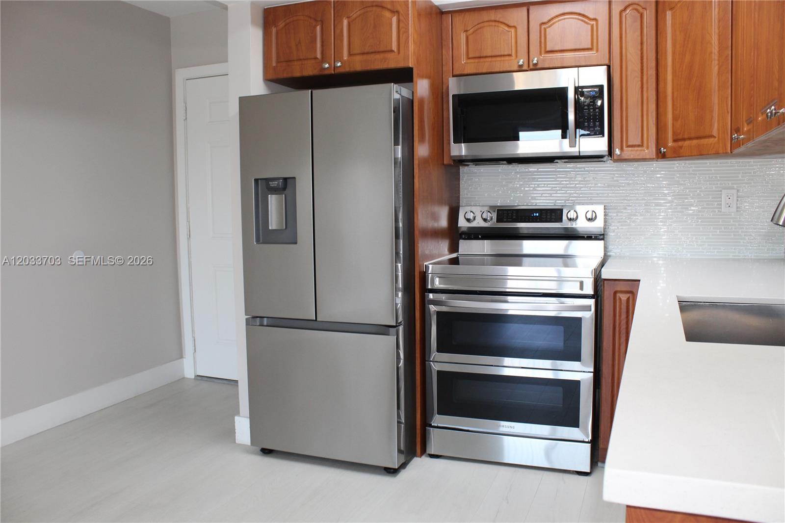 A kitchen features stainless steel appliances, wood cabinets, and a white tiled backsplash — 6780 W 2nd Ct # 401, Hialeah FL 33012, HIALEAH, FL