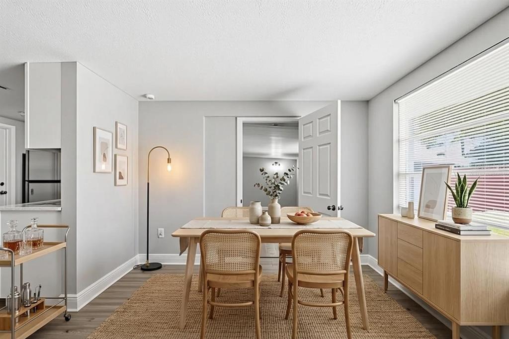 A dining room features a wooden table with cane chairs, a sideboard, and a bar cart — 7617 JASMINE BOULEVARD, PORT RICHEY, FL