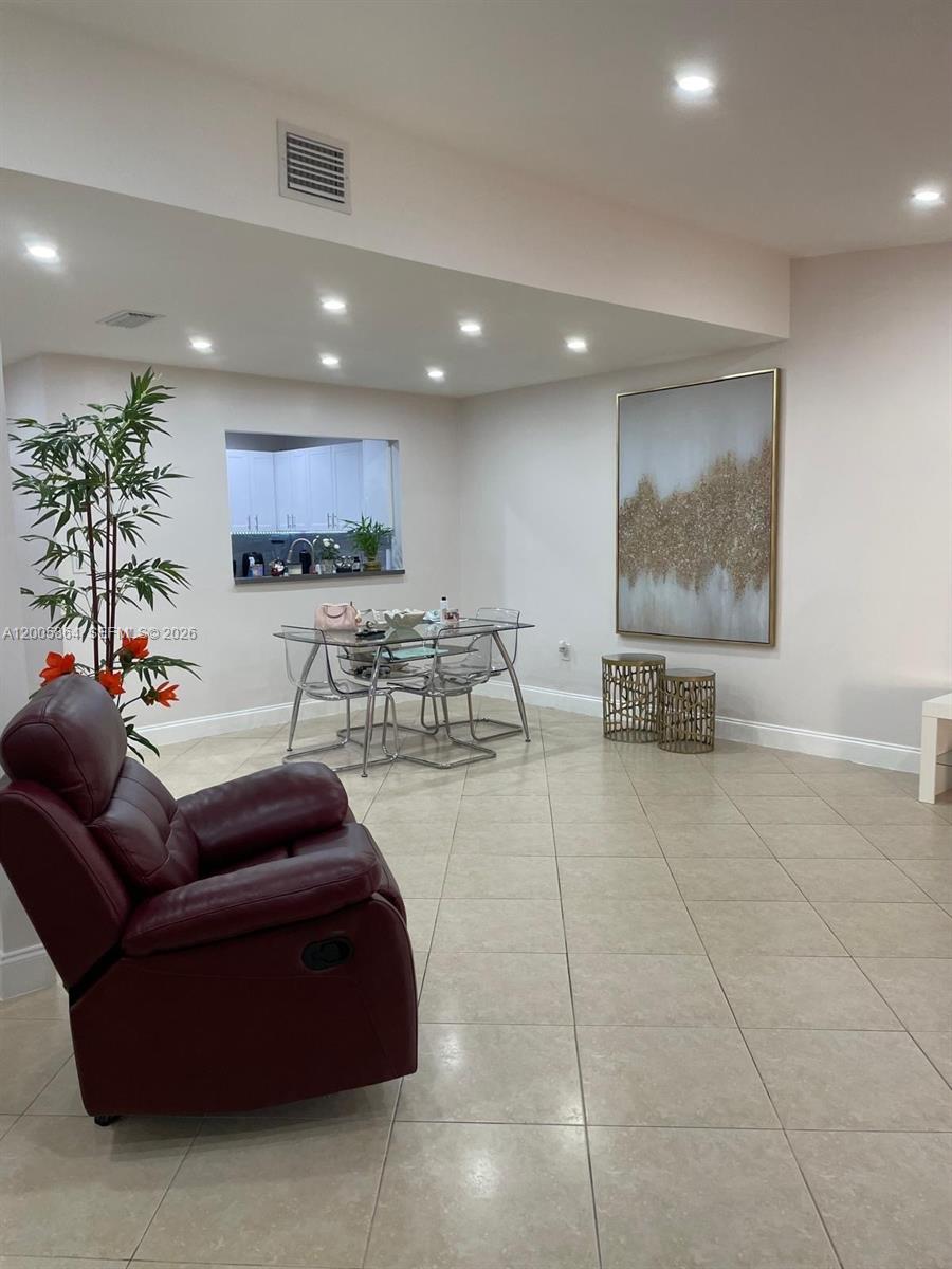 A dining area with a glass table and chairs sits adjacent to a living room — 11734 SW 112th Ln, Miami FL 33186, MIAMI, FL