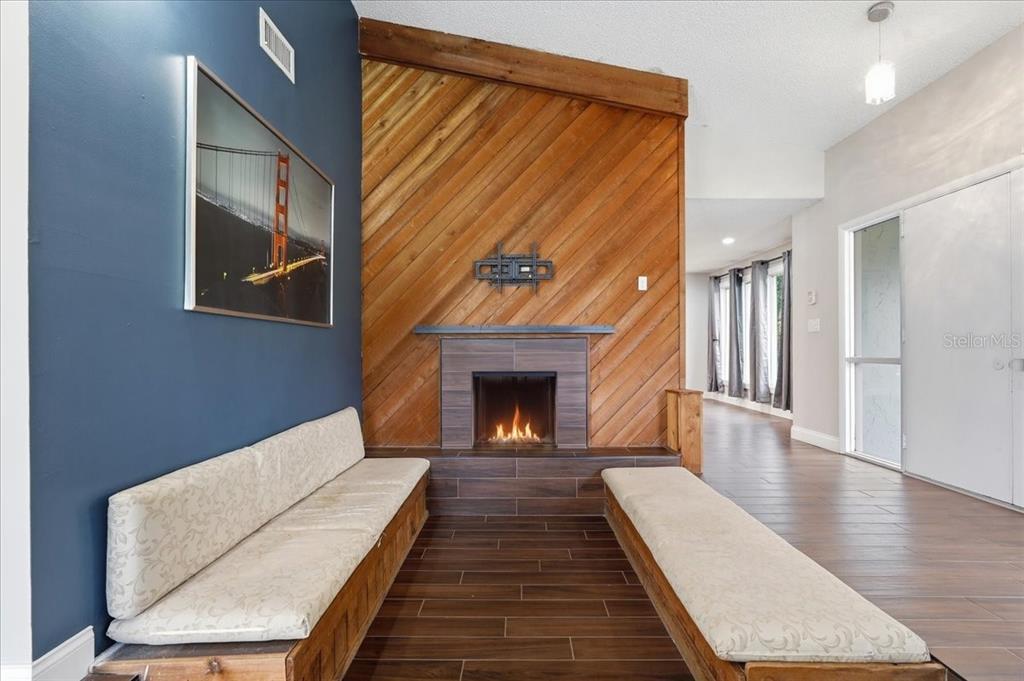 A living room features a fireplace with diagonal wood paneling and two built-in benches — 107 ELM SQUARE S, LAKELAND, FL